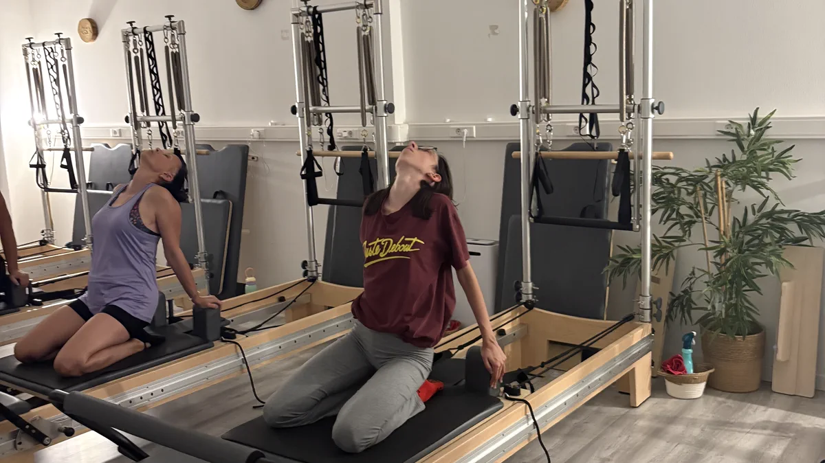 Aula de Pilates Reformer, com duas alunas no aparelho